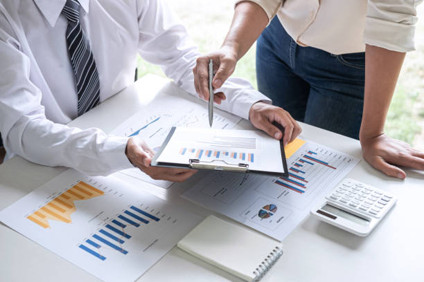 istock Midsection Of Colleagues Analyzing Data On Desk In Office 1174394803