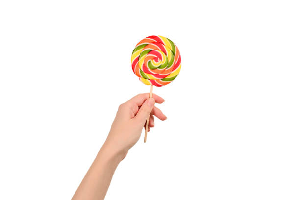 istock Lollipop in female hand isolated on white  background. Space for text or design. 1174396670