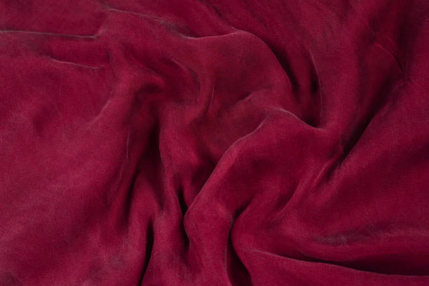 istock Soft smooth burgundy silk fabric background. Fabric texture. 1174397081