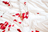 Red Rose Petals and balloons on White Bed