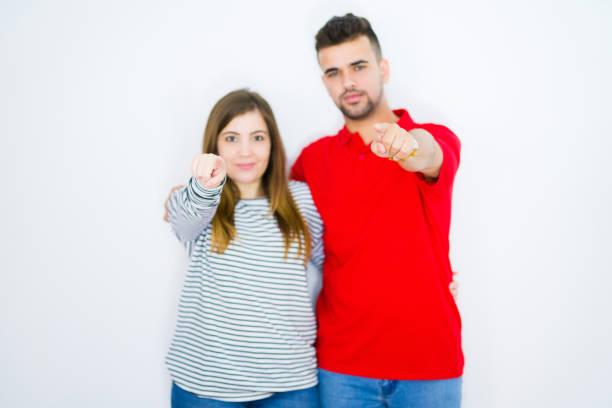 Cute young woman clung closely to her boyfriend, they are standing on the park stairs