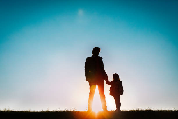 istock father with little daughter walk at sunset 1174402991