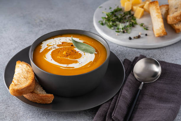 istock Pumpkin soup with cream on grey stone background. Copy space. 1174404154
