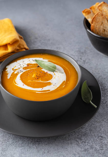 istock Pumpkin soup with cream on grey stone background. Copy space. 1174404175