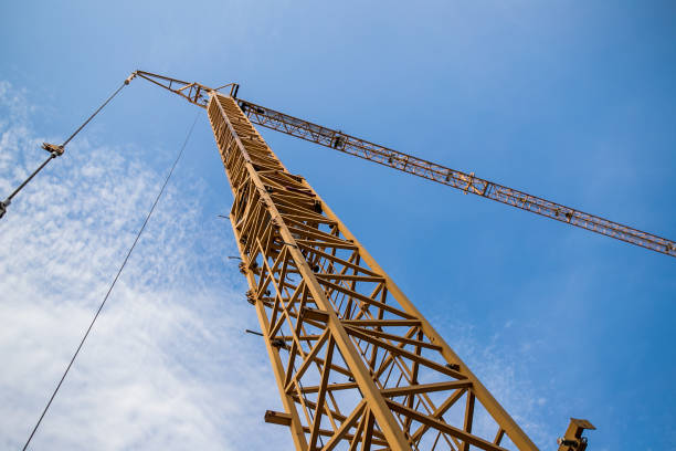 istock Construction site with cranes on sky background. Big yellow machinery construction crane tool of building industry for heavy lifting on blue sky background. Business engineering equipment modern 1174404810