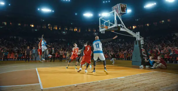 Photo of Basketball players on big professional arena during the game. Tense moment of the game. Celebration