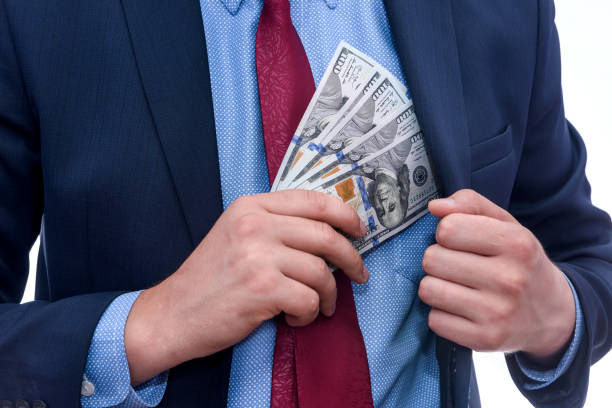 istock Businessman putting dollar banknotes to jacket pocket 1174406891