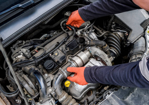 istock Mechanic examining car engine under hood close up 1174407877