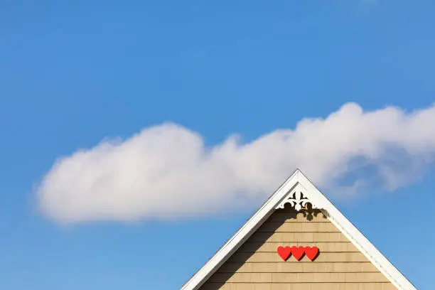 Photo of House detail with red hearts and cloud in the sky