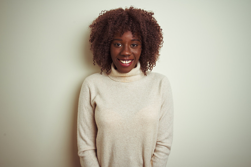 Young african afro woman wearing turtleneck sweater over isolated white background with a happy and cool smile on face. Lucky person.