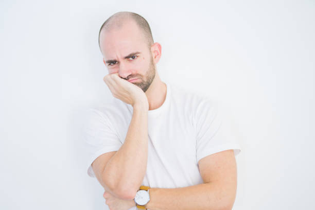 istock Young bald man over white isolated background thinking looking tired and bored with depression problems with crossed arms. 1174410173