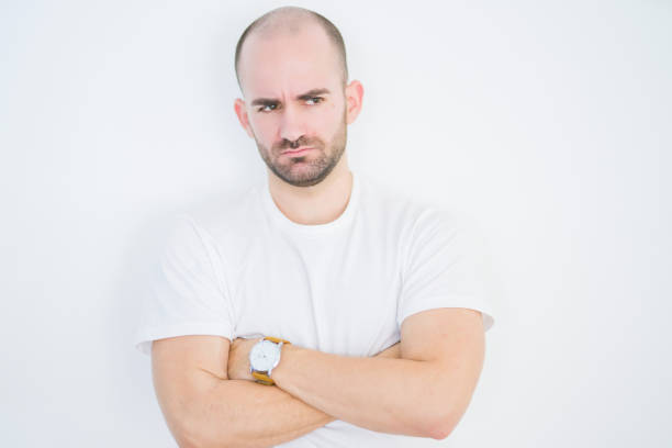 istock Young bald man over white isolated background skeptic and nervous, disapproving expression on face with crossed arms. Negative person. 1174410190