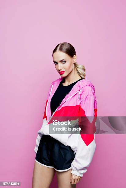 80s Style Portrait Of Beautiful Woman In Oversized Tracksuit Against Pink Background Stock Photo - Download Image Now