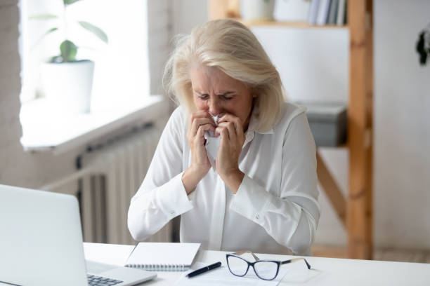istock Unhealthy senior employee blow nose suffering from cold 1174414092