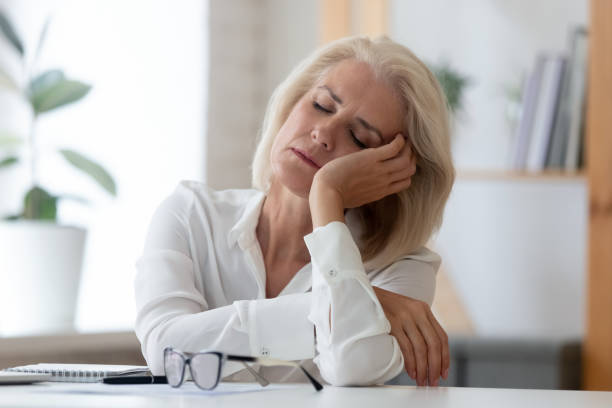 exhausted senior businesswoman fall asleep at workplace - old senior adult women tired imagens e fotografias de stock