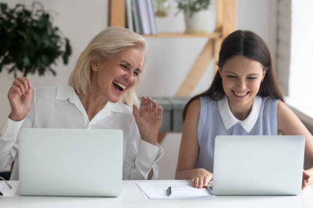 istock Happy female employee laugh using laptops in office 1174414228