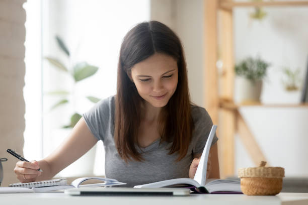 młoda dziewczyna student zajęty studia z książką w domu - child writing education nerd zdjęcia i obrazy z banku zdjęć