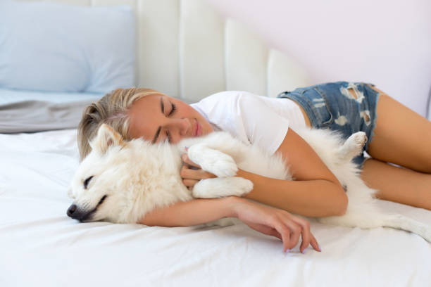 istock Woman lying on a bed with her dog 1174415473