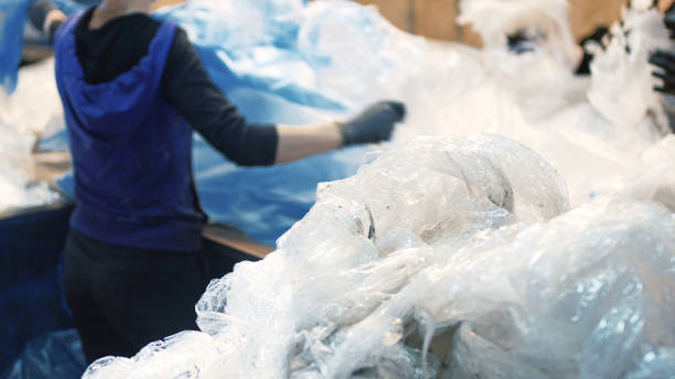 istock Workers select and sort garbage that travels on a conveyor belt in a waste recycling plant, sorting 1174415666