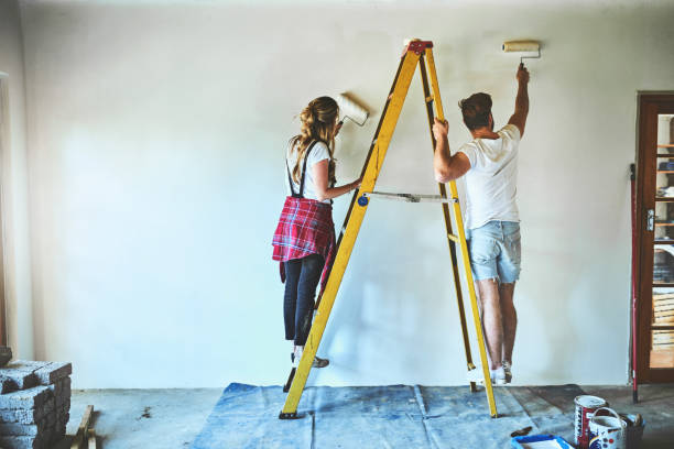 A paint job can make your house feel as good as new Shot of a young couple painting the walls of their new home together wall renovation stock pictures, royalty-free photos & images