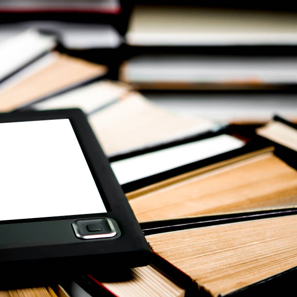 istock The e-book with a white screen lies on the open multi-colored books that lie on a dark background, close-up 1174421170