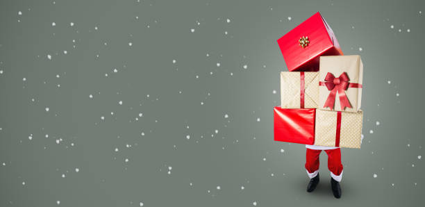 istock Santa carrying a big stack of Christmas presents 1174421970