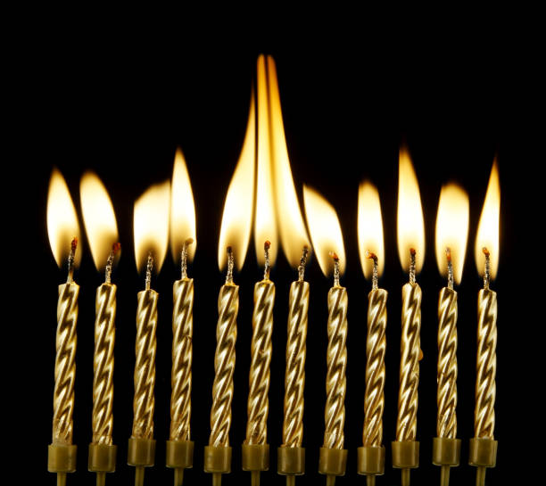 istock Burning golden candles on black background 1174422993