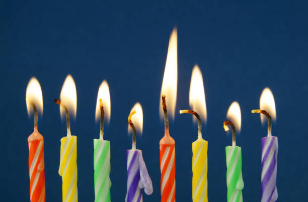 istock Burning colorful candles on blue background 1174423166
