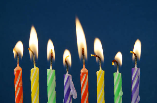 istock Burning colorful candles on blue background 1174423217