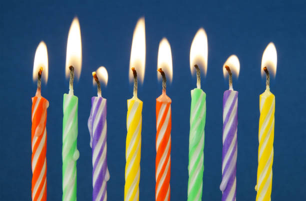 istock Burning colorful candles on blue background 1174423363