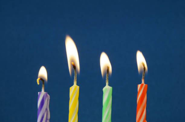 istock Burning colorful candles on blue background 1174423382