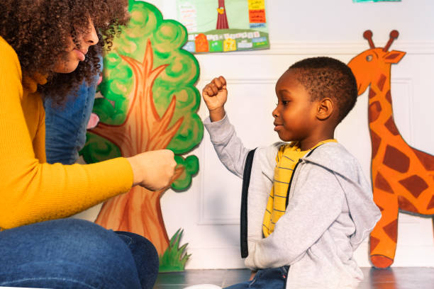 istock Teacher and little boy play rock paper scissors 1174427364