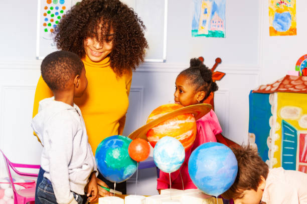 istock Group of kids in nursery school play learn planet 1174427430