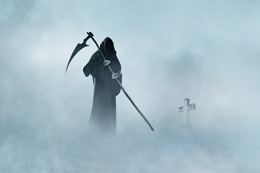 Grim Reaper walking in fog. Halloween.