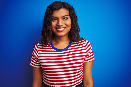 Transsexual transgender woman wearing stiped t-shirt over isolated blue background with a happy and cool smile on face. Lucky person.