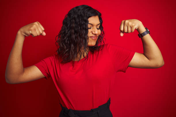 beautiful transsexual transgender woman wearing t-shirt over isolated red background showing arms muscles smiling proud. fitness concept. - red t shirt imagens e fotografias de stock