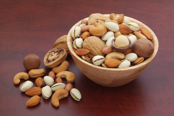 istock Many mixed nuts in wooden bowl 1174430962