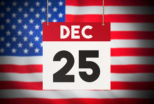 Calendar standing in front of the American flag and showing DEC 25 Stock Image