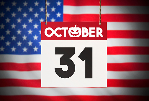 Calendar standing in front of the American flag and showing OCT 31 Stock Image