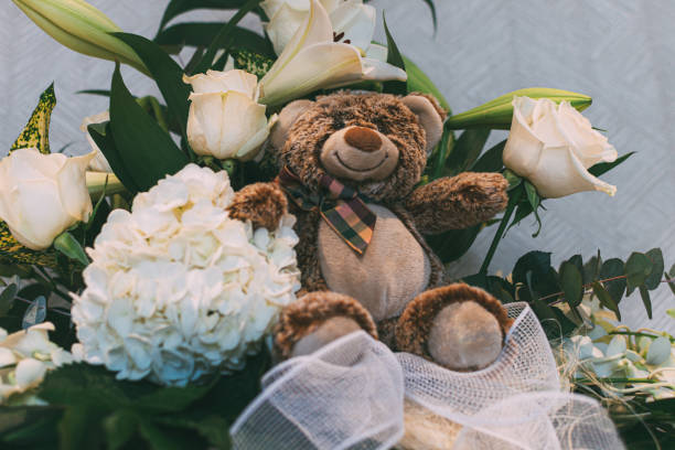 istock Brown teddy bear between a flowers bouquet 1174431677