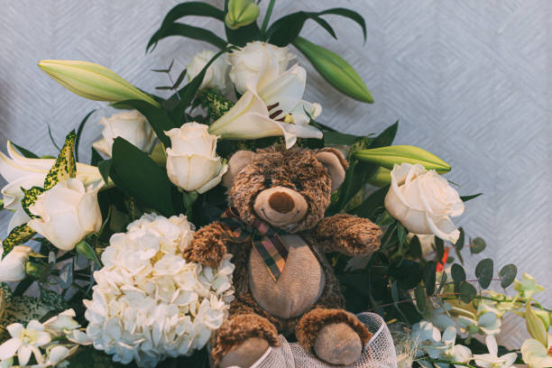 istock Bunch of roses and a teddy bear on white background 1174431678