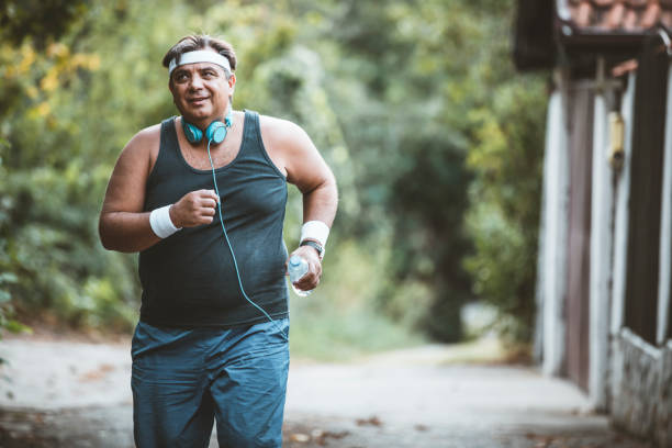 istock Fat man slowly running outdoors, active lifestyle as struggle with obesity 1174431990