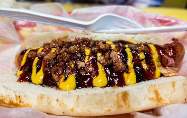 Freshly prepared hot dog with mustard and barbecue sauces