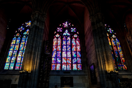 Colorful stained glass window in st. Vitus Cathedral in Prague, Czech Republic. Concept of Gothic interior decoration.
