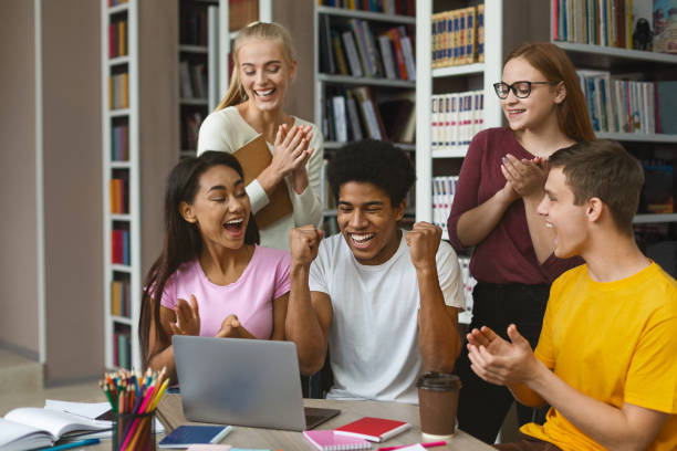 istock College friends congratulating euphoric african american guy 1174433685
