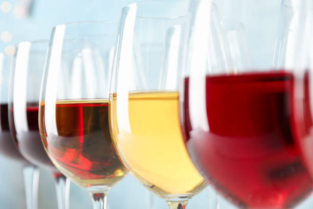 istock Glasses with wine against light blue background, blurred lights, closeup 1174434772