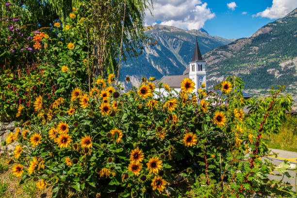 Church on top of hill below glaciated mountains