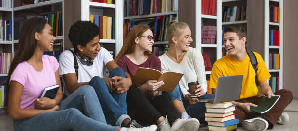 compagni di classe che si divertono mentre studiano nella biblioteca del campus - nerd computer learning fun foto e immagini stock