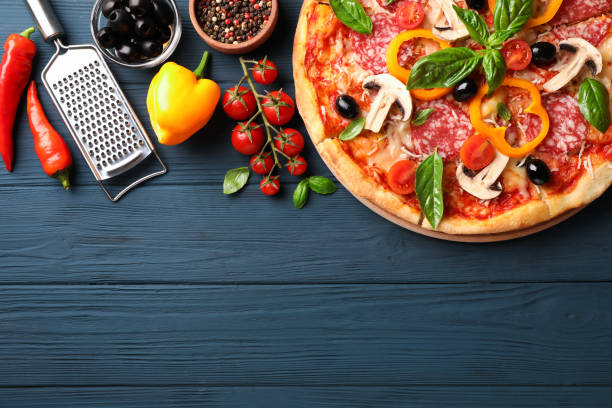 istock Delicious pizza and ingredients on wooden background, copy space 1174435266