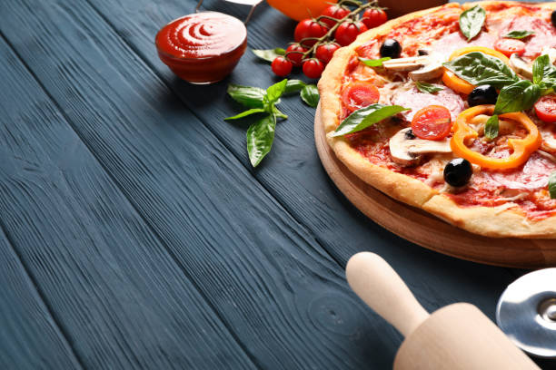 istock Delicious pizza and ingredients on wooden background, copy space 1174435382